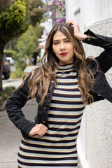 Fototapeta premium female model with red lips makeup, beautiful young woman with long blonde hair, wear striped casual dress and jean jacket, latin model beauty, city street lifestyle