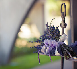 Sprigs of lavandi tied together and bags with lavender petals as a floral arrangement for a wedding