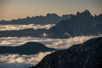 Low inversion clouds between mountain layers during sunrise in the Dolomite Alps in South Tyrol, Italy.