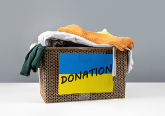 clothing for donation for Ukrainian refugees. Donation box with ukraine flag used clothes to...