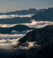 Low inversion clouds between mountain layers during blue sky day in the Dolomite Alps in South...