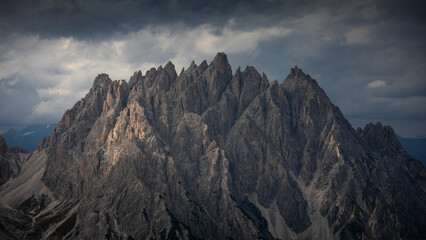 Haunold mountain chain with dark clouds during sunset at Three Peaks Hut in the Dolomite Alps in South Tyrol, Italy.