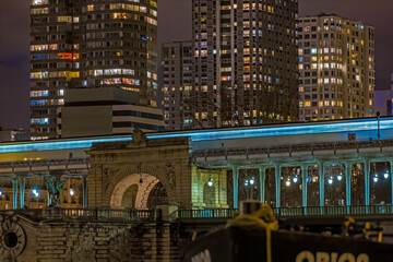 Bir Hakeim Bridge and Subway Enlightened at Night in Paris With Buildings and Hotel Behind