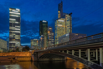 Fototapeta premium La Defense District Skyline at Dusk Under Cloudy Sky With Seine and Bridge