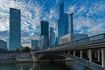 Fototapeta na wymiar Cloudy Sunset Over La Defense Business District Seine River and Bridge Buildings and Towers