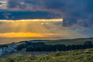 Fototapeta premium Intense Yellow Light at Sunset Through the Clouds in French Lowland Mountains