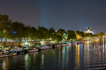 Fototapeta premium Night Traffic at Paris Famous Monuments Seine River Boats Docks and Bridge