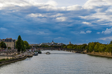 Fototapeta na wymiar Stormy Sky Over Paris Seine River and Boats Bridges Monuments
