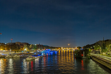 Fototapeta premium Full Moon Over Seine River in Paris at Night With Boats Cruises and Tourists