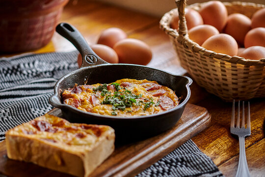 desayuno colombiano huevos con tostadas en una mesa de madera con luz de ventana