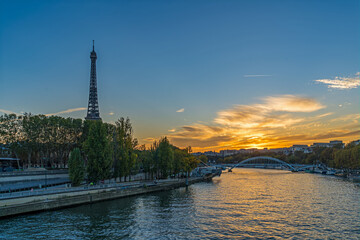 Fototapeta na wymiar Eiffel Tower at Golden Hour in Paris With Colorful Clouds Seine River and Tourist Cruises