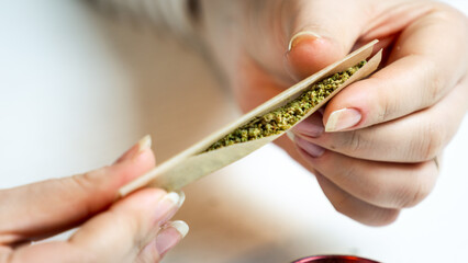 Close-up of female hand holding medical marijuana joint. Concept of herbal and alternative medicine