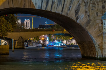 Blue  Boat Cruise on Seine River at Night With Stone Bridges and Notre Dame Cathedral in Paris