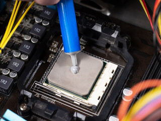 A man applies thermal paste to install the microprocessor on the motherboard.Maintenance of the hardware of the computer processor.