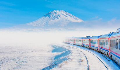Red diesel train (East express) in motion at the snow covered railway platform - The train...