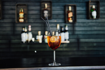 Red alcoholic cocktail with tequila, strawberry syrup, lime and crushed ice, in a glass in a bar.