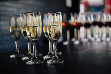 Glasses with a champagne and wine on black table in the bar.