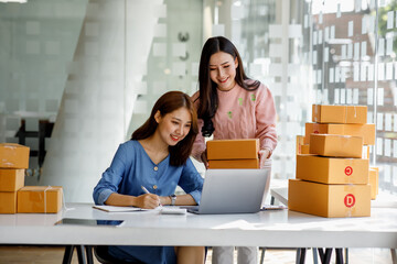 Portrait of Starting small businesses SME owners, two Asian woman check online orders Selling products working with boxs freelance work at home office, sme business online small medium enterprise