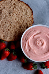 Strawberry cream, cake layers and juicy strawberries on a table. Close up photo of homemade cake in process. Layer cake ingredients top view. 