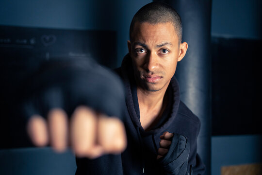 Hispanic male boxer shadow fighting in gym