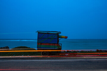 Miroissa, Sri Lanka An old shack on the side of the road along the seashore at night.