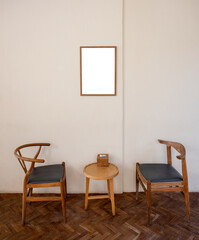 Wooden armchair with table and empty picture frame in living room