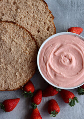 Strawberry cream, cake layers and juicy strawberries on a table. Close up photo of homemade cake in process. Layer cake ingredients top view. 