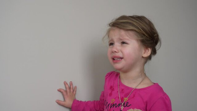Little angry caucasian kid. Furious capricious toddler kid got upset and sad. Stubborn child bad attitude. Depressed little girl complaining with mom.