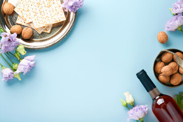 Pesach Jewish holiday. Passover celebration concept. Matzah, red kosher wine and walnut. Traditional ritual Jewish bread on light blue background. Passover food. © kasia2003
