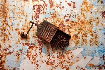 Obraz premium stary młynek do kawy i ziarna kawy na kolorowym tle 