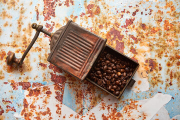 Naklejka premium stary młynek do kawy i ziarna kawy na kolorowym tle 