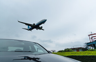 Fototapeta na wymiar An airplane flying over the car