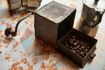 stary młynek do kawy i ziarna kawy na kolorowym tle 