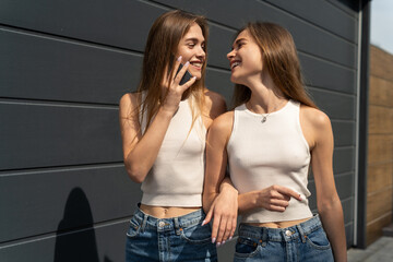 Happy girls walking on the street. Women talking on the phone. Women talking on the phone