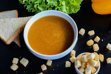 lentil soup, delicious lentil cream-soup with lemon and small pieces of twice-baked bread, rusk