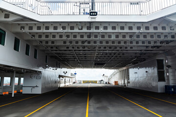 The inner deck of a sea ferry with a superstructure and a covered room for transporting vehicles.