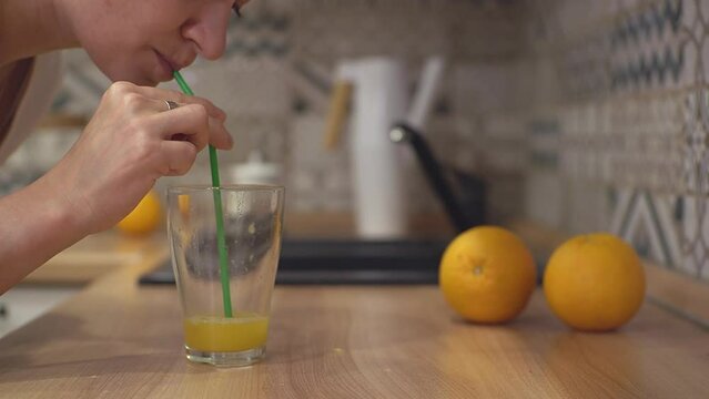 a girl drinks juice through a straw
