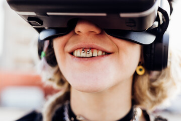 Diverse young pierced woman toothy smile enjoying augmented reality wearing vr headset videogaming...