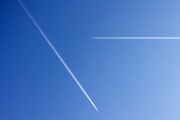 Flugzeuge mit Kondensstreifen am blauen Himmel. 