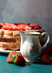 Vintage milk jug close up photo. Beautiful strawberry cake on a background. Tea time concept. 