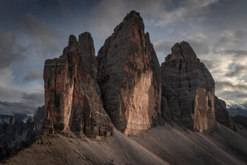 Fototapeta premium Three Peaks mountain summits in the Dolomite Alps in South Tyrol with clouds during sunset.
