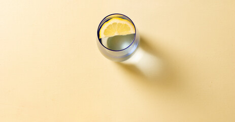 vaso con limón y fondo amarillo pastel