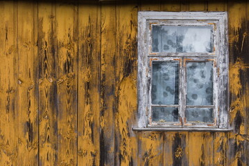 Rustic window in wooden village cottage house. Yellow wood wall