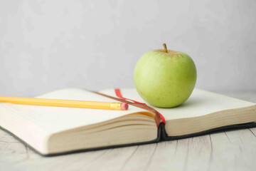 black to school concept with apple on notepad on table.