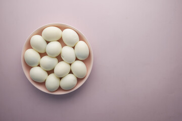 top view of bowel egg in a bowl on purple background 