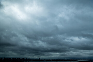 Fototapeta na wymiar Dark clouds over a city by the sea
