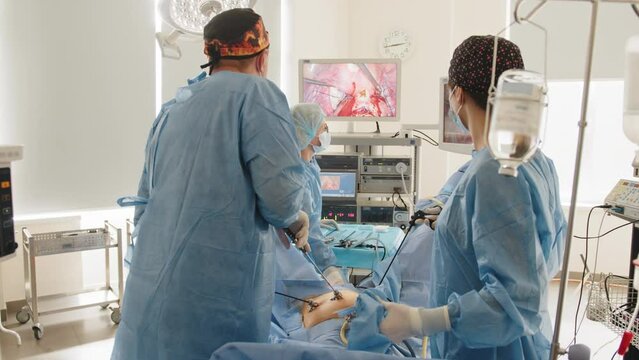 Operation using laparoscopic equipment. Process of gynecological surgery operation using laparoscopic equipment. Group of surgeons in operating room with surgery equipment