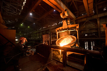 Steelworker at work near the tanks with hot metal - 496161770