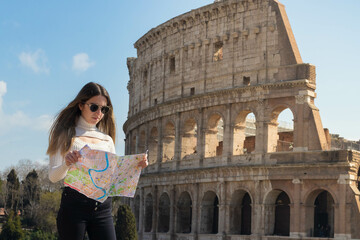 Young tourist woman in Rome with map and the Roman coliseum in the background