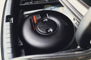Car donut-shaped LPG tank in a spare wheel hole on the car trunk - obrazy, fototapety, plakaty